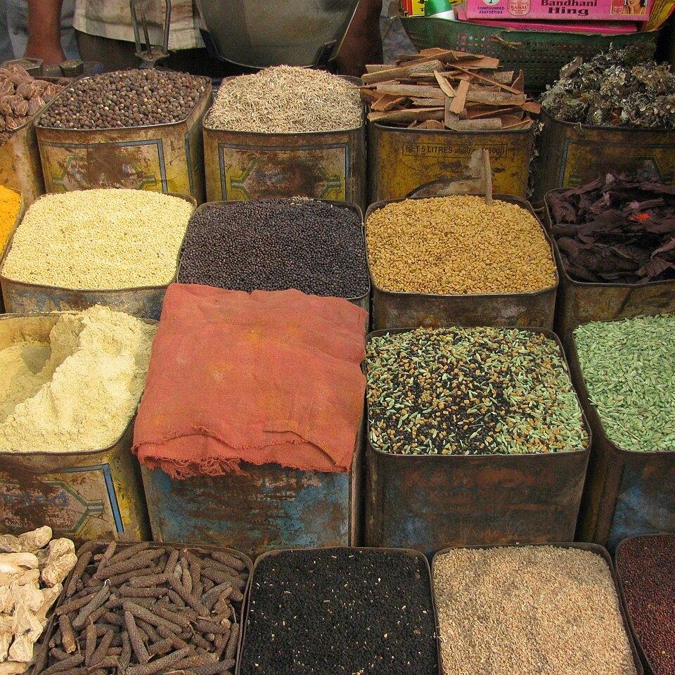 Indian spices and pulses displayed in tins at a market